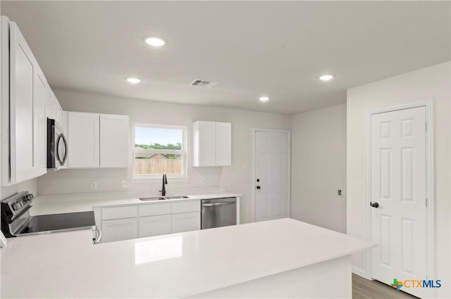 1007 Antelope Trl, Temple, TX 76504 - kitchen with stainless steel appliances, a peninsula, recessed lighting, light countertops, and white cabinets