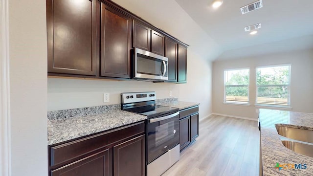 kitchen featuring appliances with stainless steel finishes, visible vents, light wood-style floors, and dark brown cabinets