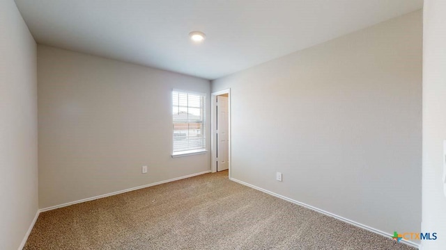 carpeted spare room with baseboards