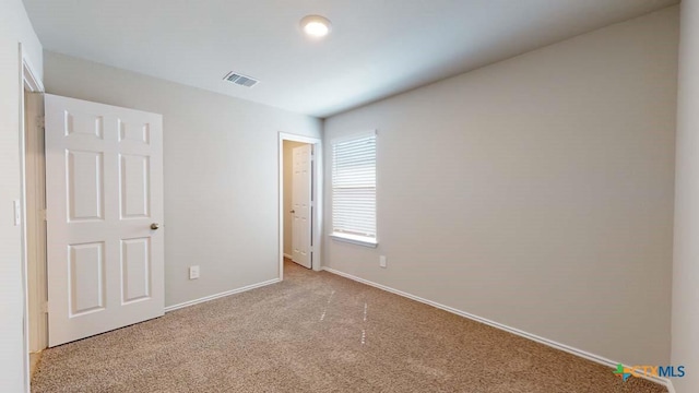 unfurnished bedroom with carpet floors, visible vents, and baseboards