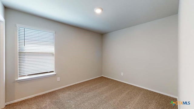 carpeted spare room with baseboards