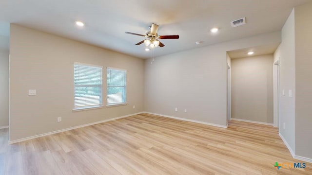 unfurnished room with light wood-type flooring, ceiling fan, visible vents, and baseboards