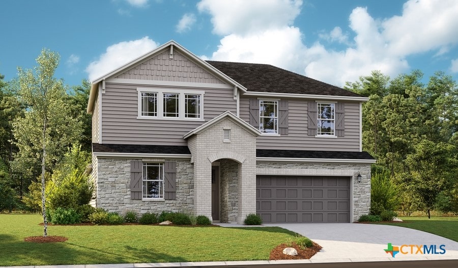 view of front of home with a garage and a front lawn