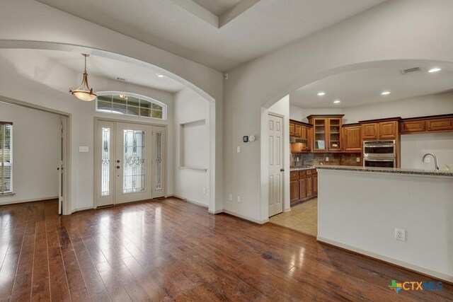 living room with a fireplace, a tray ceiling, and wood-type flooring