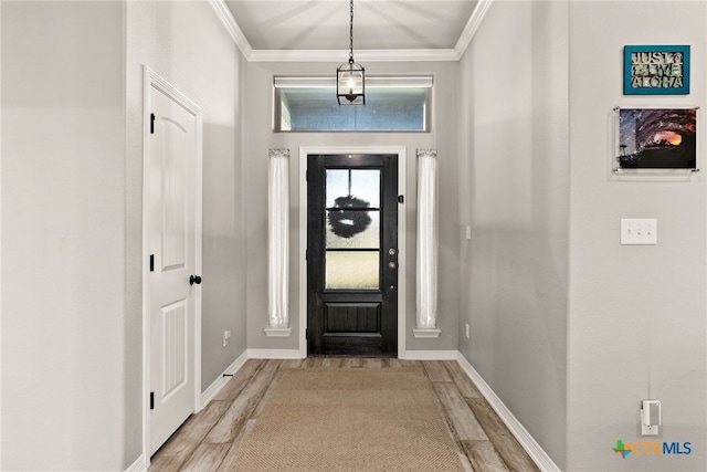 foyer featuring ornamental molding and light wood-type flooring