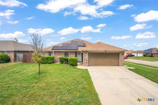 3801 Joshua Taylor Dr, Killeen, TX 76549 - ranch-style home with brick siding, a garage, roof mounted solar panels, concrete driveway, and a shingled roof