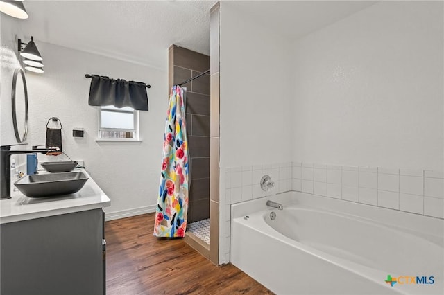 3801 Joshua Taylor Dr, Killeen, TX 76549 - full bathroom with double vanity, a shower stall, a bath, wood finished floors, and baseboards