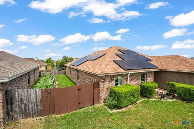 3801 Joshua Taylor Dr, Killeen, TX 76549 - view of side of property featuring a gate, brick siding, roof mounted solar panels, and roof with shingles