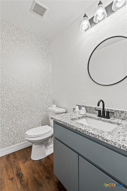 3801 Joshua Taylor Dr, Killeen, TX 76549 - bathroom with vanity, wood finished floors, toilet, and a textured wall