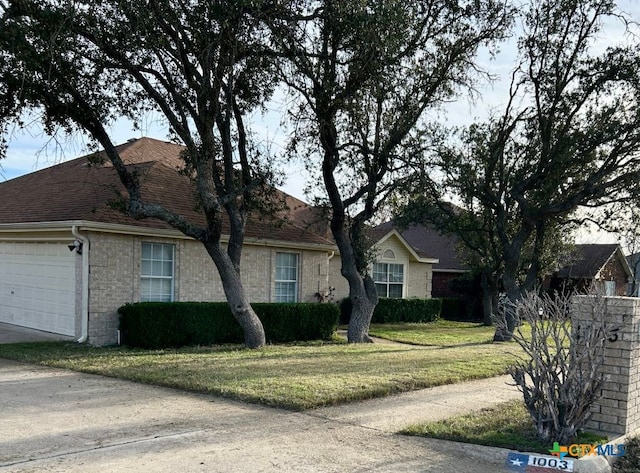 single story home featuring a garage and a front yard