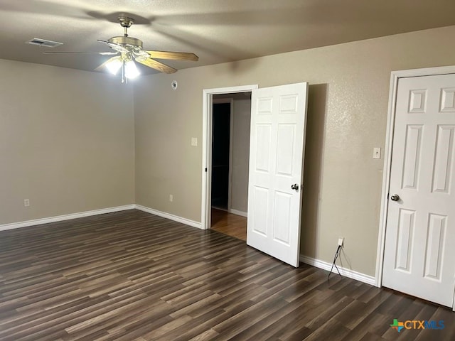 spare room with dark hardwood / wood-style flooring and ceiling fan