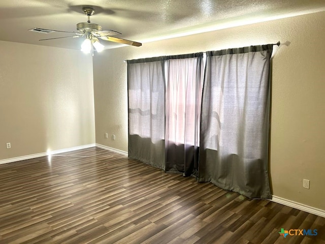 empty room with ceiling fan, a textured ceiling, and dark hardwood / wood-style flooring