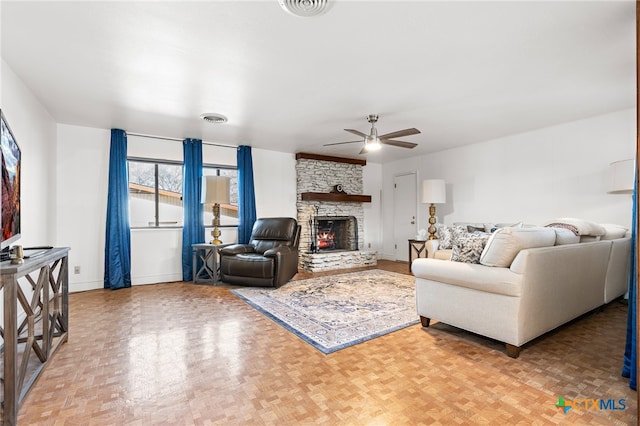 living room featuring parquet flooring, ceiling fan, and a fireplace