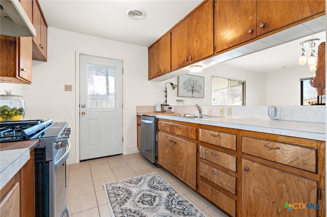 kitchen with ventilation hood, appliances with stainless steel finishes, sink, and light tile patterned floors