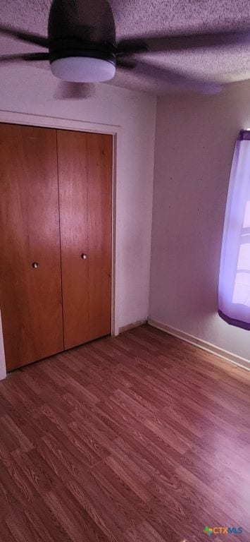 unfurnished bedroom featuring a textured ceiling, hardwood / wood-style flooring, and ceiling fan