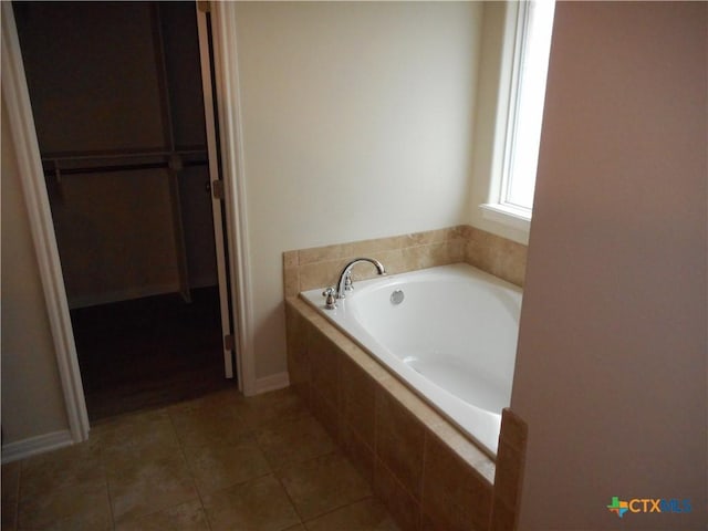 bathroom with tiled bath and tile patterned floors