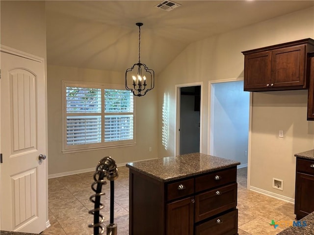 kitchen featuring lofted ceiling, decorative light fixtures, dark stone countertops, an inviting chandelier, and dark brown cabinetry