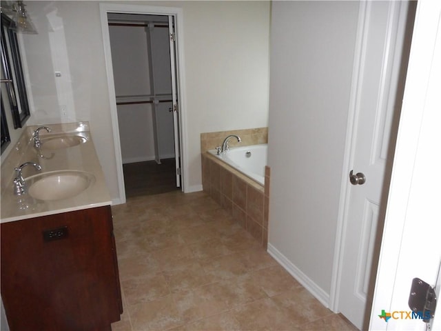 bathroom with tiled tub and vanity