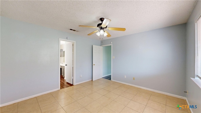 unfurnished bedroom featuring a textured ceiling, visible vents, tile patterned flooring, and ceiling fan