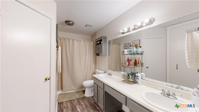 full bathroom featuring a sink, a textured ceiling, toilet, and wood finished floors