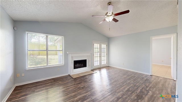 unfurnished living room with a textured ceiling, vaulted ceiling, wood finished floors, ceiling fan, and a fireplace