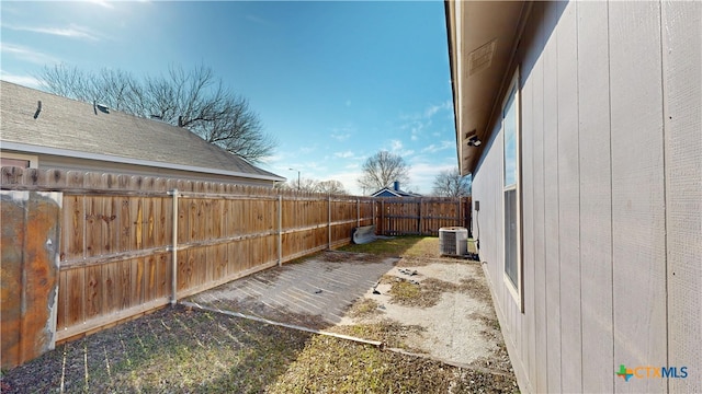 view of yard with central air condition unit and a fenced backyard