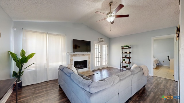 living room featuring ceiling fan, lofted ceiling, dark wood-style flooring, and a textured ceiling