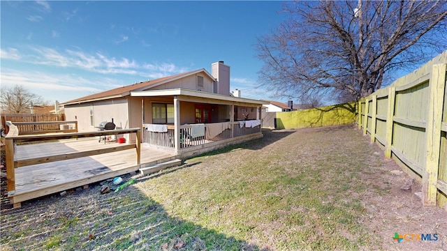 view of side of property with a chimney, a fenced backyard, and a wooden deck