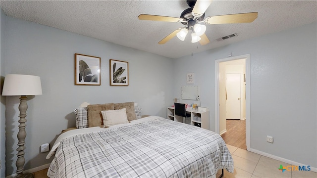 bedroom featuring visible vents, baseboards, ceiling fan, and light tile patterned floors