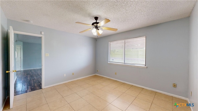 spare room with a textured ceiling, a ceiling fan, baseboards, and light tile patterned floors