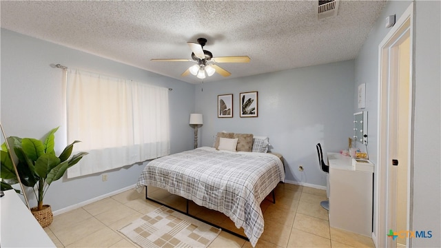 bedroom with visible vents, light tile patterned flooring, ceiling fan, a textured ceiling, and baseboards