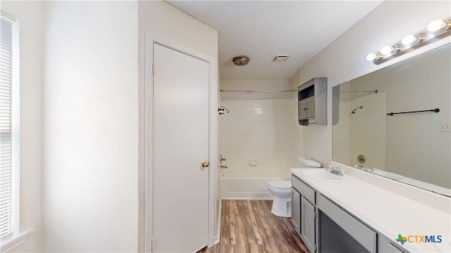 bathroom with wood finished floors, vanity, shower / bath combination, toilet, and visible vents