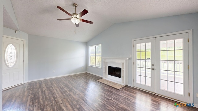 unfurnished living room featuring vaulted ceiling, a ceiling fan, wood finished floors, and a textured ceiling