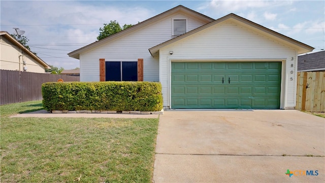 view of front of home featuring an attached garage, driveway, a front lawn, and fence