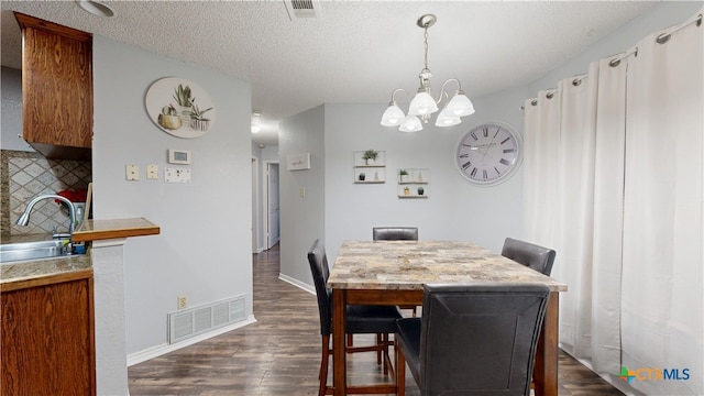 dining area with visible vents, dark wood finished floors, a textured ceiling, and baseboards