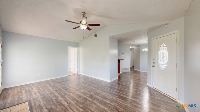 entryway with a textured ceiling, vaulted ceiling, visible vents, a ceiling fan, and dark wood-type flooring