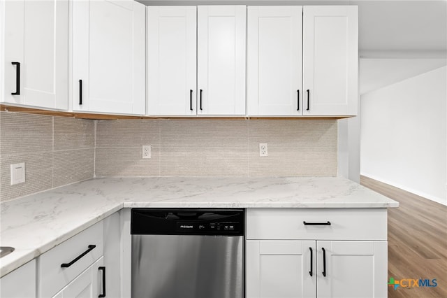 kitchen with hardwood / wood-style flooring, white cabinetry, light stone counters, tasteful backsplash, and stainless steel dishwasher