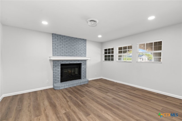 unfurnished living room featuring a fireplace and hardwood / wood-style flooring