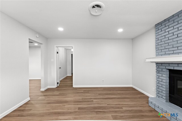 unfurnished living room with a fireplace and wood-type flooring