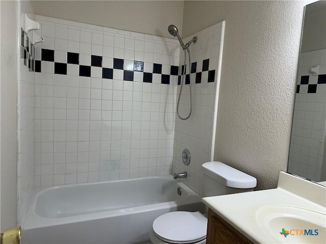 bathroom featuring toilet, a textured wall, shower / bath combination, and vanity