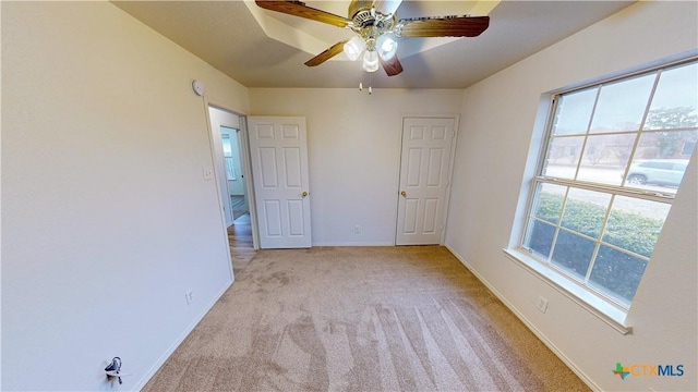 unfurnished bedroom with light carpet, ceiling fan, and baseboards