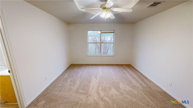 spare room with ceiling fan, baseboards, visible vents, and light colored carpet