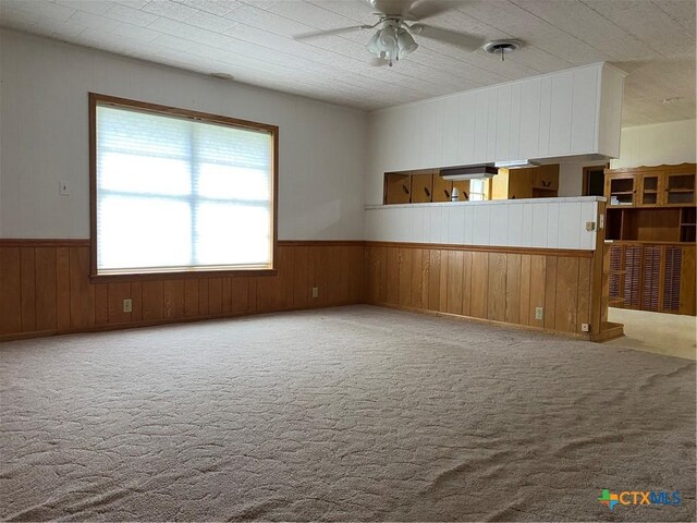 589 Bluebonnet Ln, Yoakum, TX 77995 - carpeted empty room featuring wooden walls, ceiling fan, and wainscoting