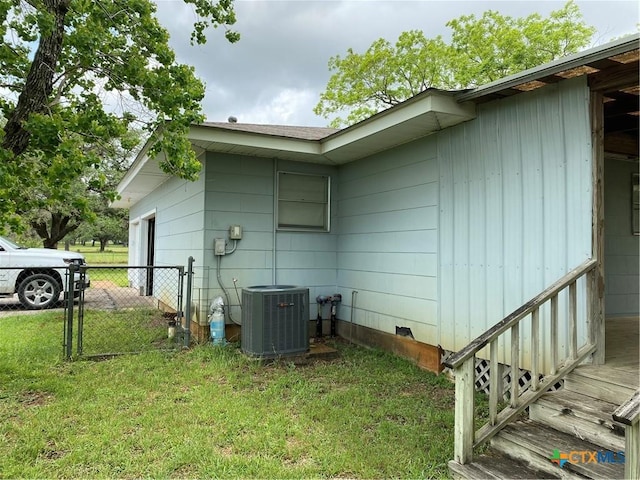 589 Bluebonnet Ln, Yoakum, TX 77995 - view of property exterior featuring crawl space, a lawn, central AC unit, a garage, and fence