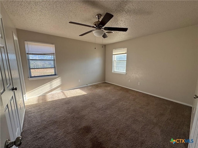 spare room featuring ceiling fan, a textured ceiling, and dark colored carpet