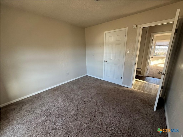 unfurnished bedroom with dark carpet