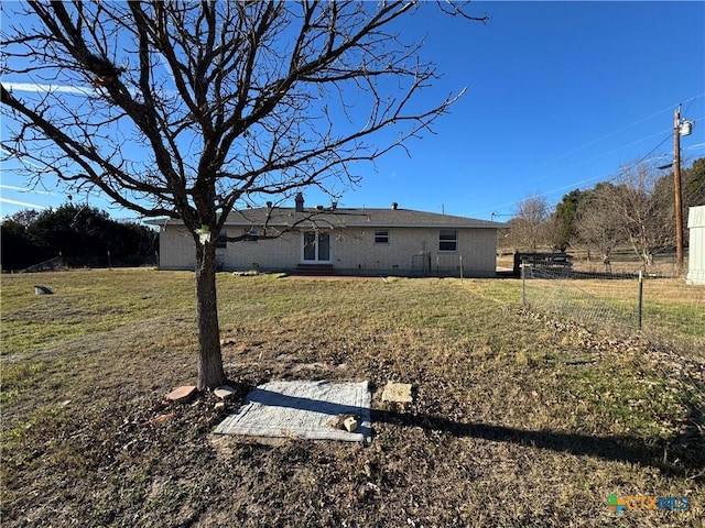 rear view of property featuring a lawn