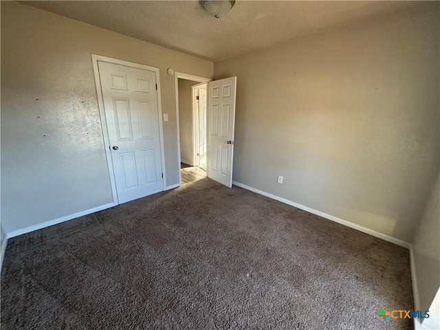 unfurnished bedroom featuring carpet and a textured ceiling