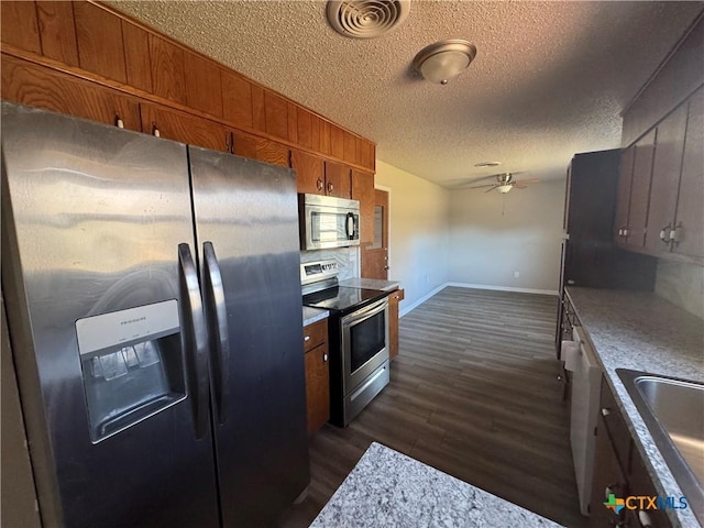 kitchen featuring a textured ceiling, dark hardwood / wood-style flooring, stainless steel appliances, sink, and ceiling fan