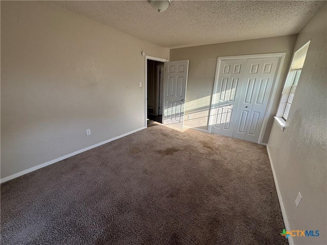 empty room featuring carpet, plenty of natural light, and a textured ceiling